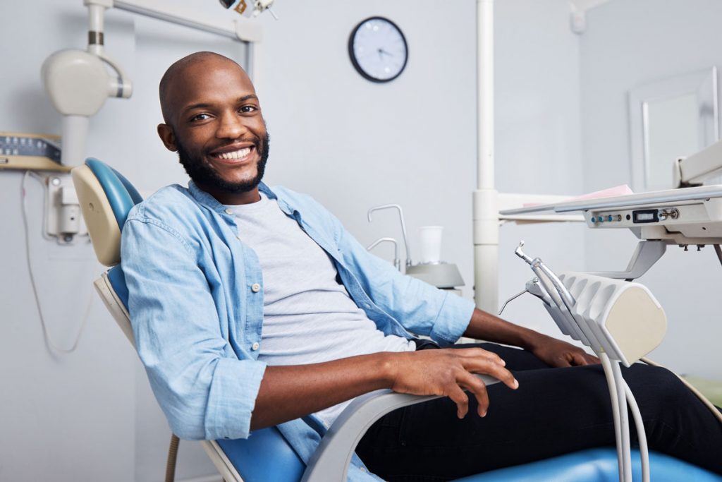smiling male patient in dental exam chair